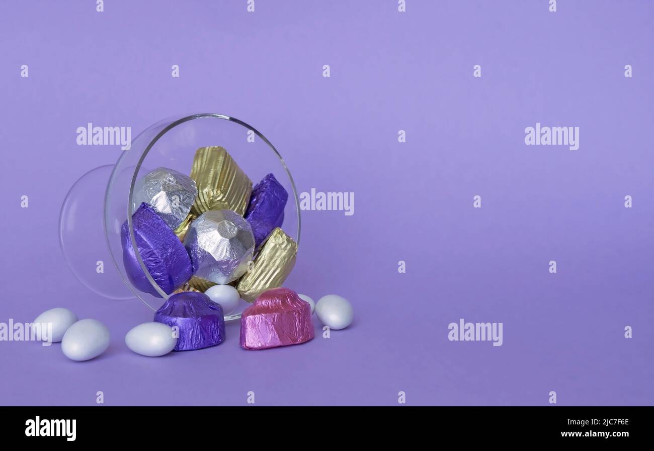 Feast Concept, Traditional Turkish Ramadan sweet sugar candy, and chocolates in glass bowl with purple background. Stock Photo
