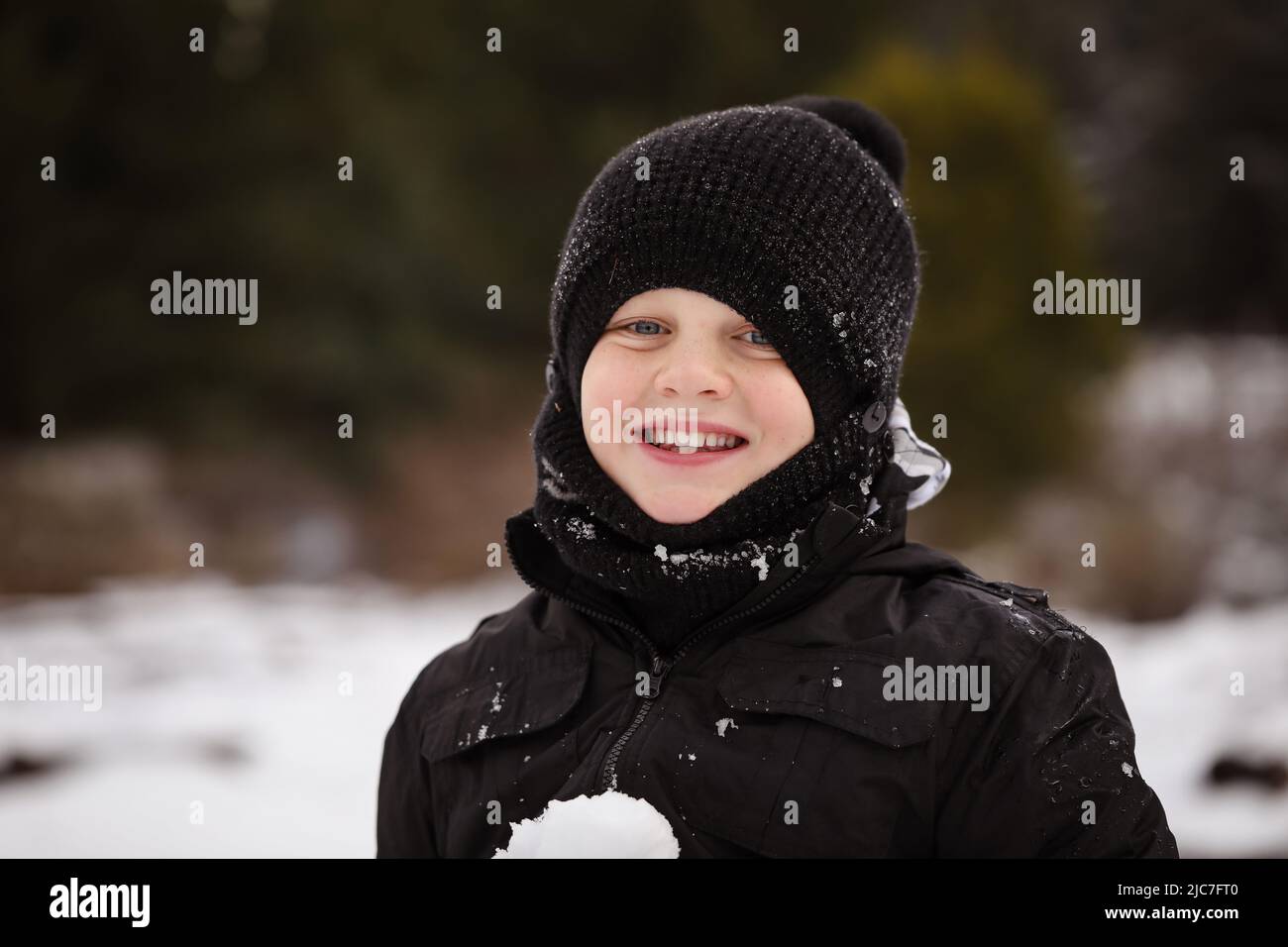 Boy in the snow with snow ball having snowball fight Stock Photo