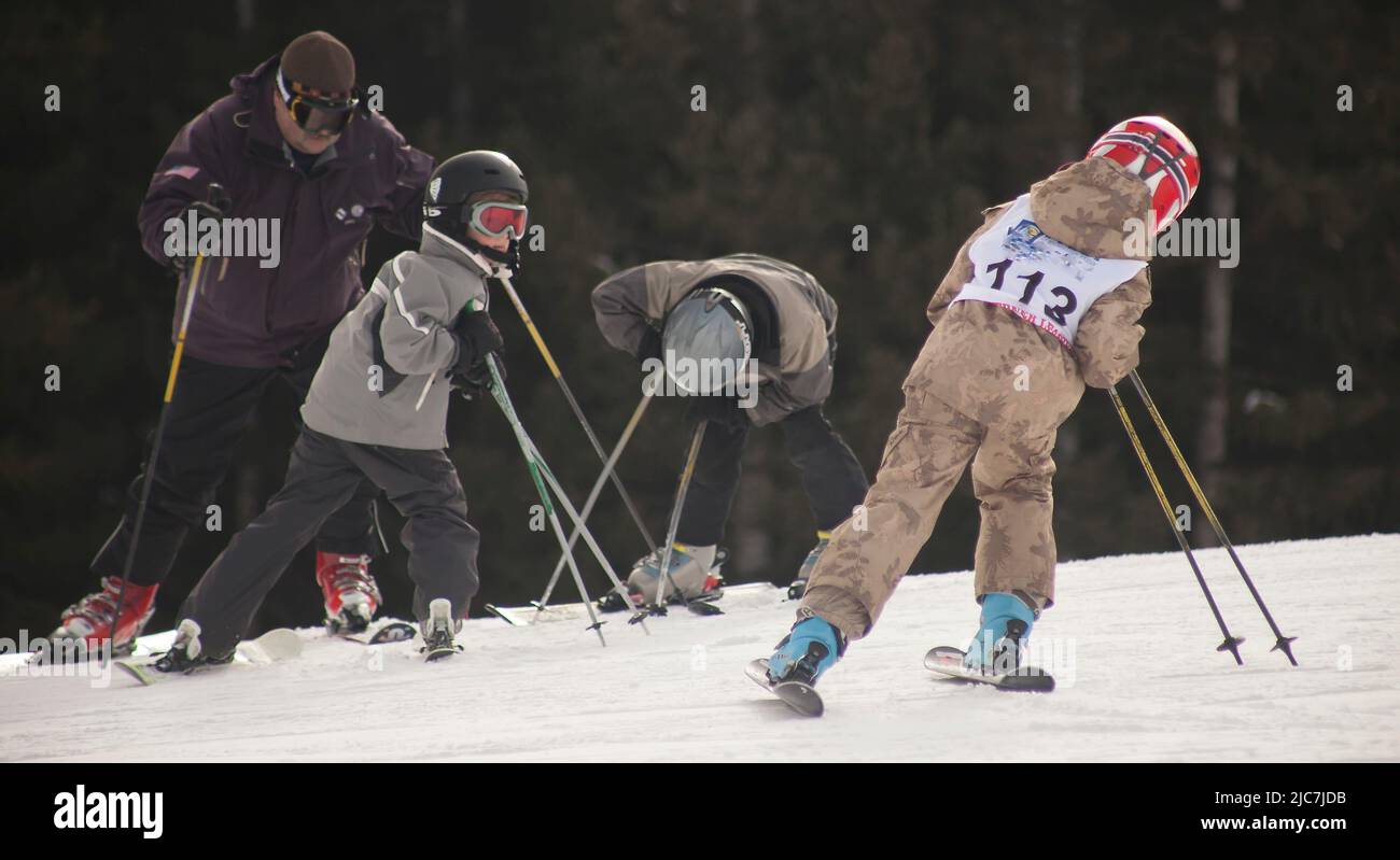 Instructor teaching children to ski Stock Photo