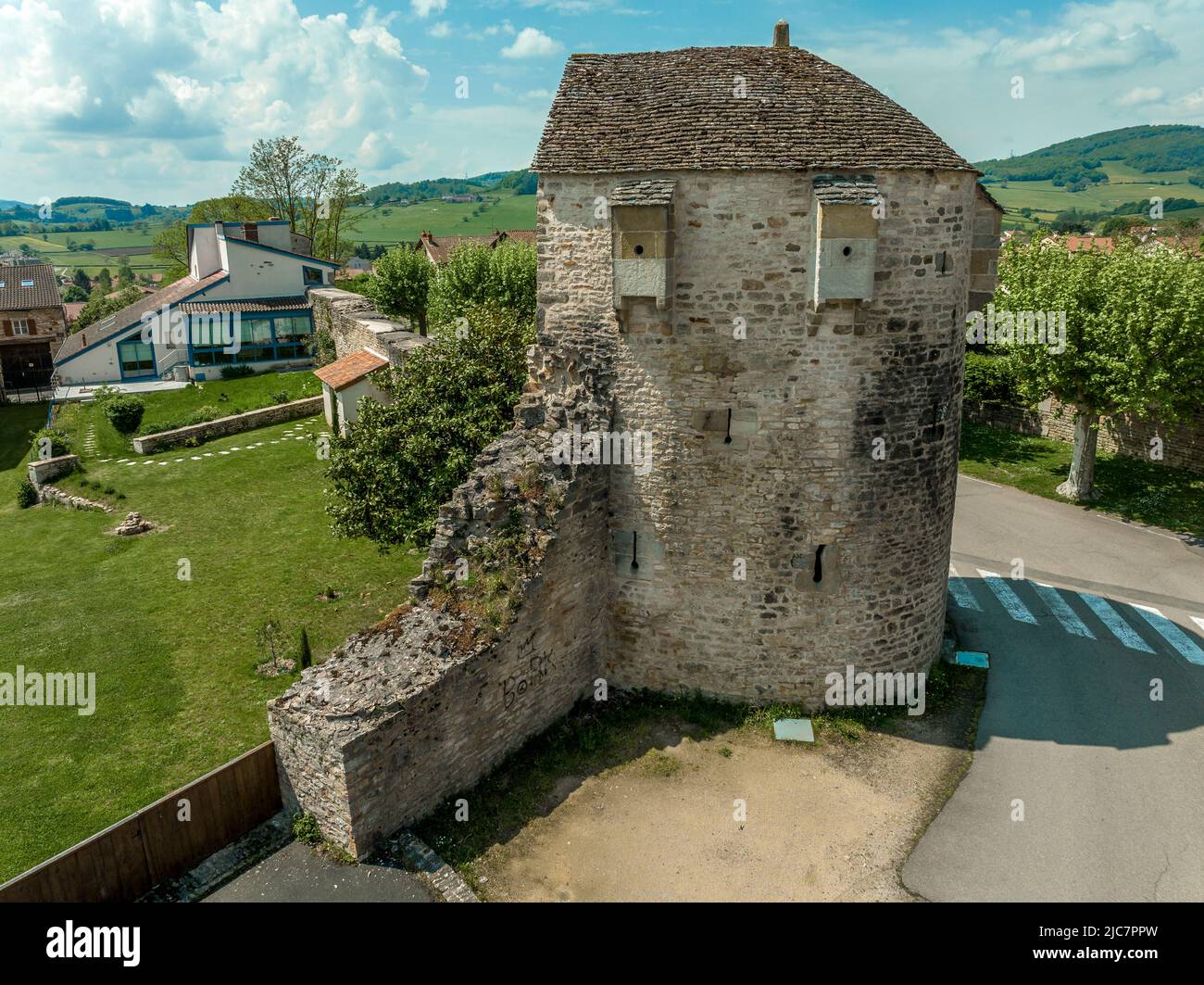 Circular defensive tower with loopholes piercing the town walls of Cluny protecting the ancient religious center and abbey Stock Photo