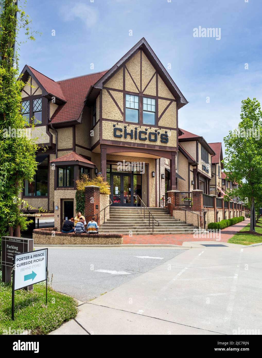 BILTMORE VILLAGE in ASHEVILLE, NC, USA-5 JUNE 2022: Chico's Clothing store, entrance and Chalet architecture.  4 people in front. Stock Photo