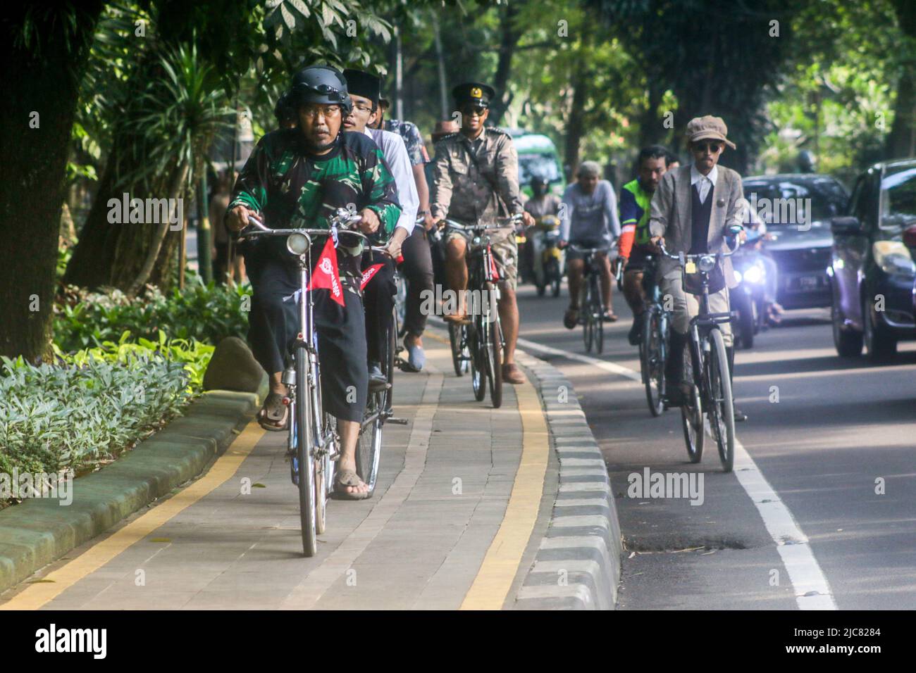 Members of the Onthel community together with the Indonesian Old Bike Community, cycle around the city to celebrate World Bicycle Day Stock Photo