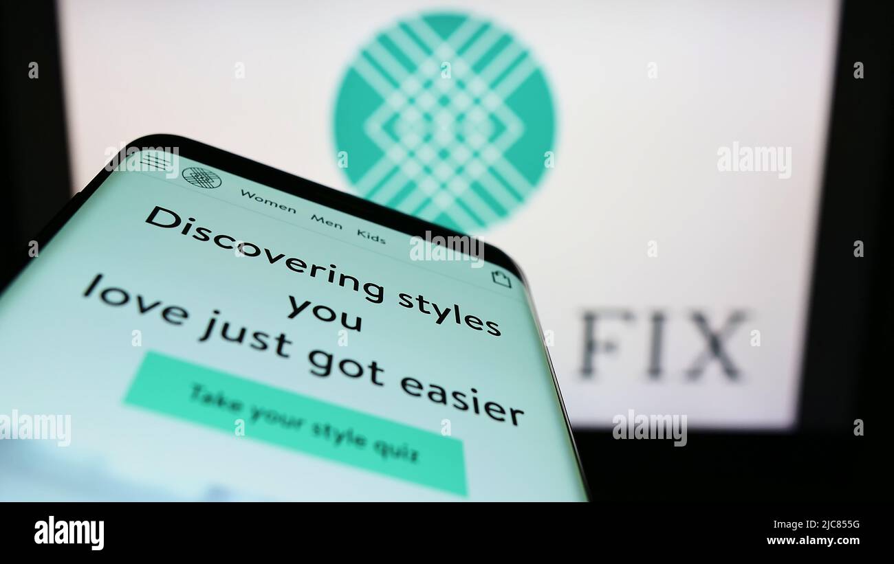Mobile phone with website of US styling company Stitch Fix Inc. on screen in front of business logo. Focus on top-left of phone display. Stock Photo
