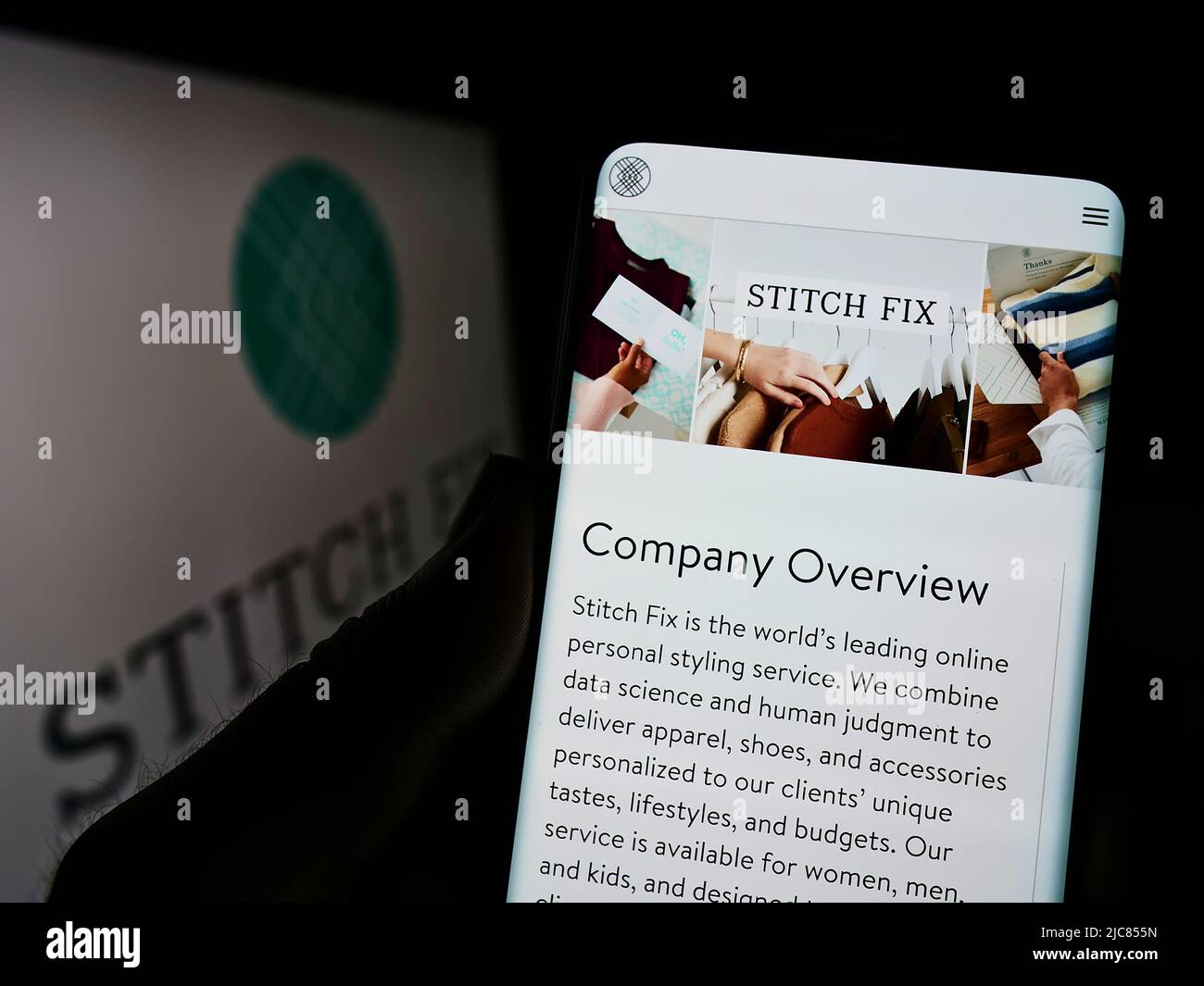 Person holding cellphone with webpage of US styling company Stitch Fix Inc. on screen in front of logo. Focus on center of phone display. Stock Photo