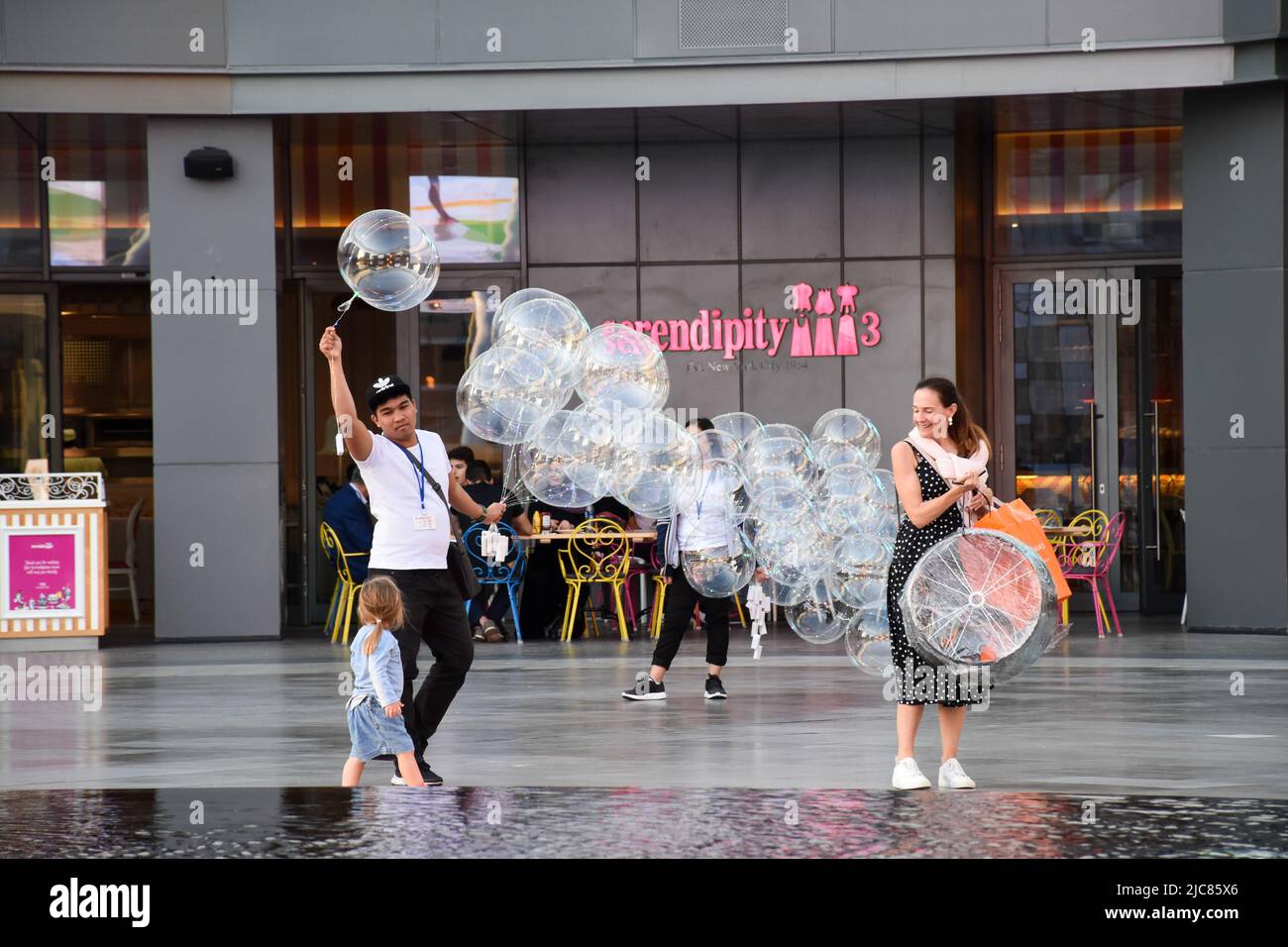 A street vendor selling clear LED balloons outside the Serendipity 3 restaurant in Dubai. Stock Photo