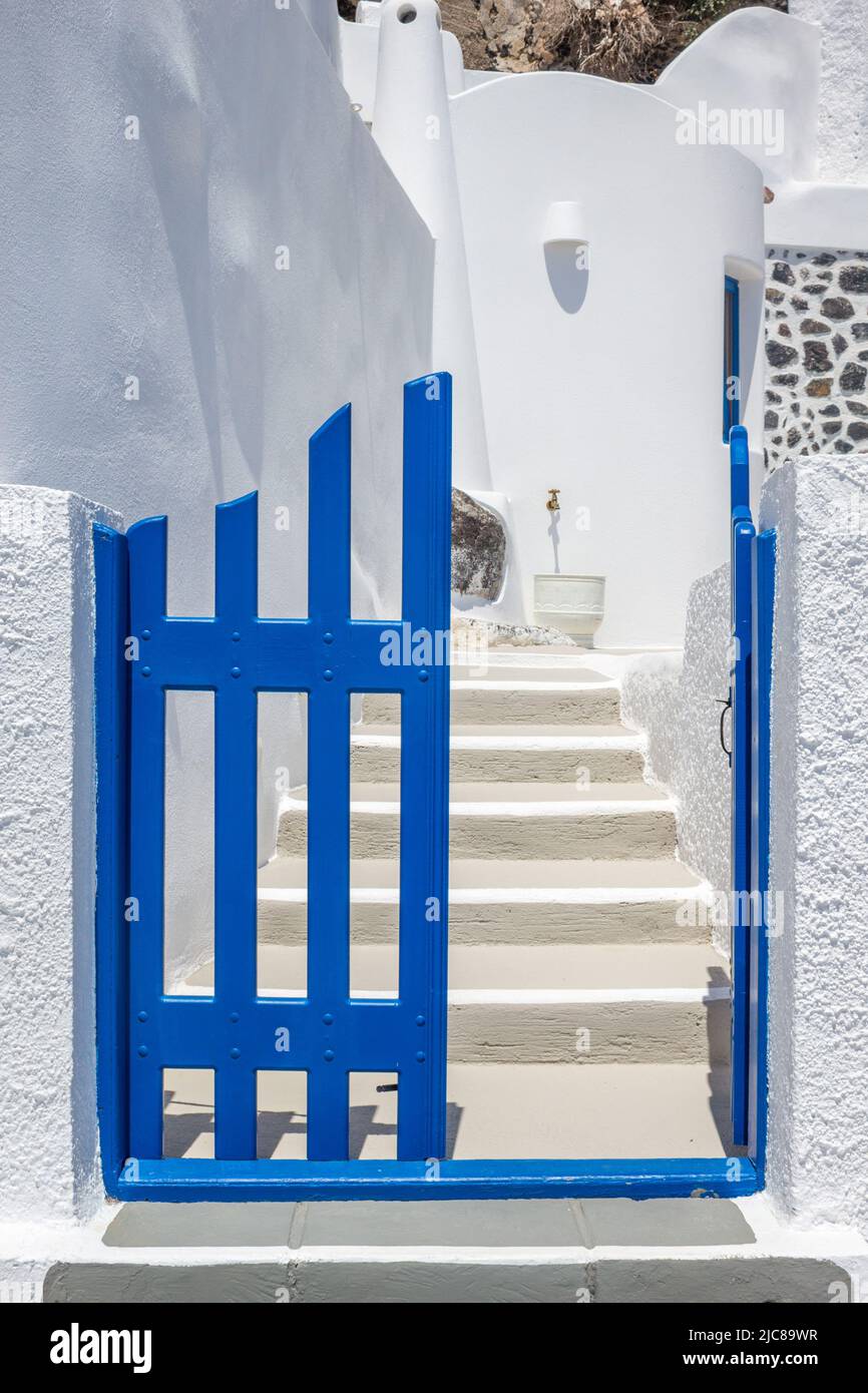 Entrance to a traditional Greek island styled home with a blue gate and whitewashed steps and walls. Taken on the island of Santorini, Greece. Vertica Stock Photo