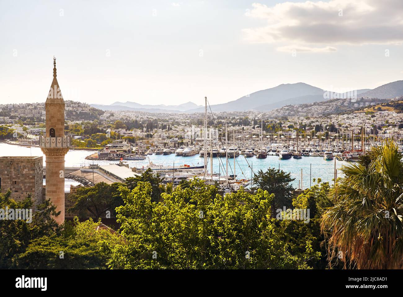 View of Bodrum Beach from castle and mosque tower. Sailing boats, yachts at Aegean sea with traditional white houses at hills in Bodrum town Turkey Stock Photo