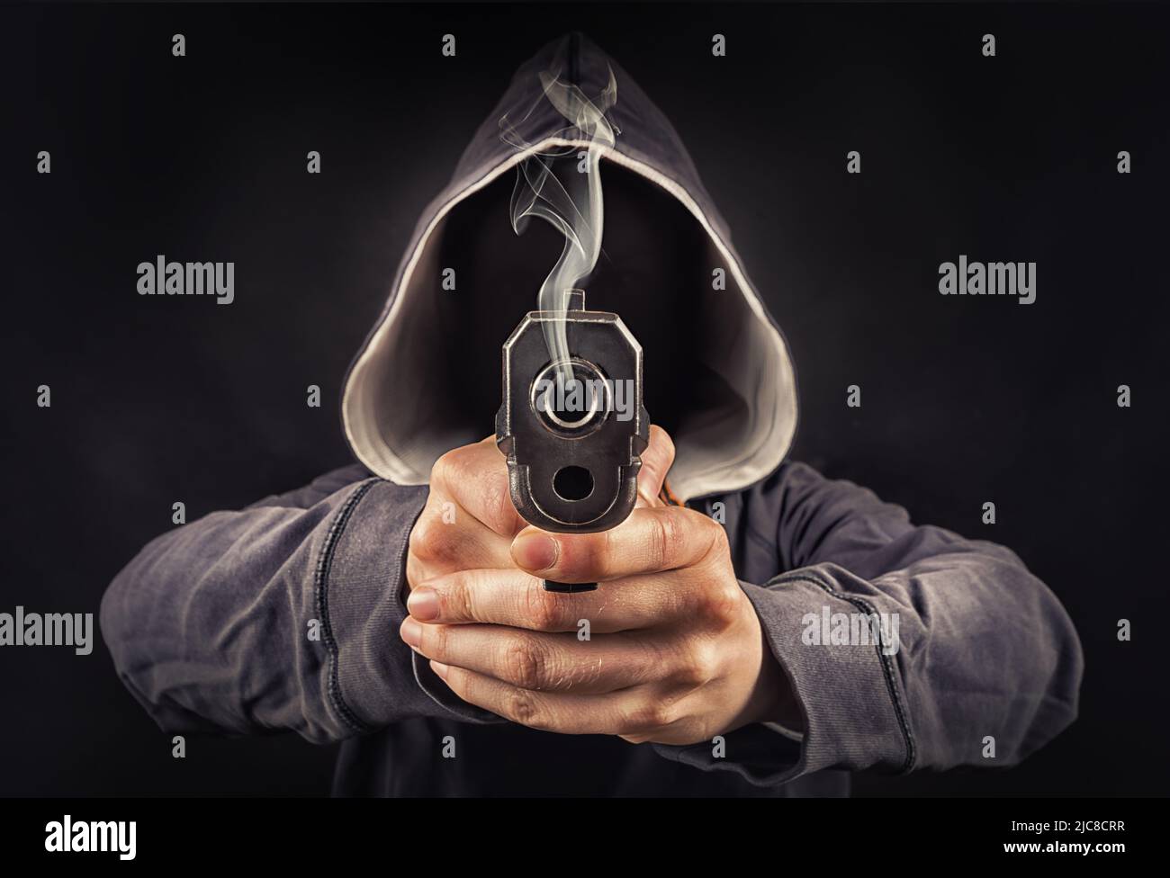 faceless man with a pistol in his hands Stock Photo