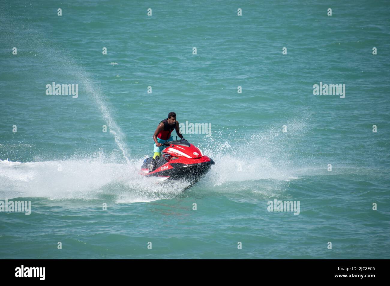 A young Indian male driving a jet ski in the Arabian Gulf, Kuwait City Stock Photo