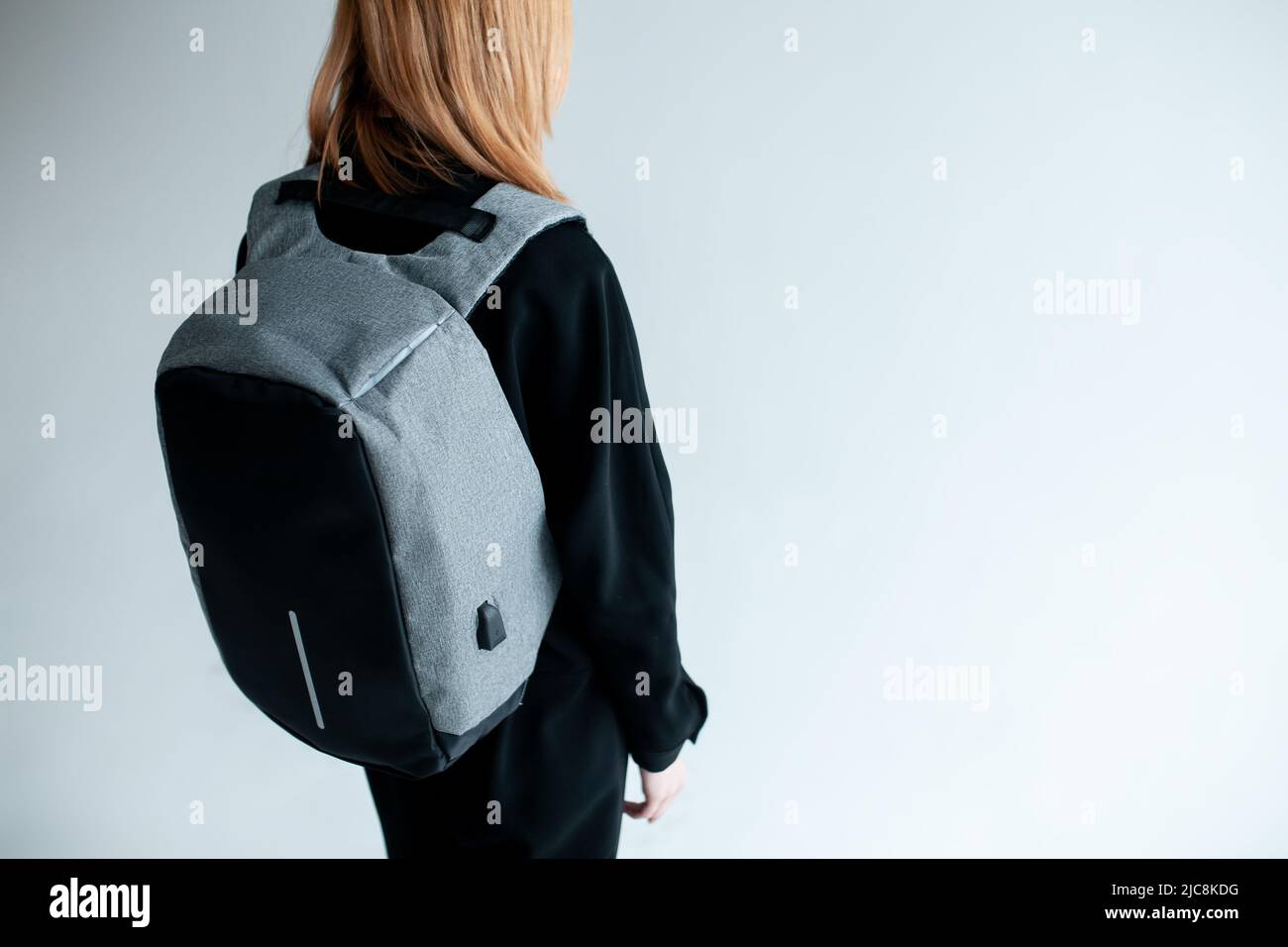 stylish hipster person holding modern backpack bag on white background Stock Photo