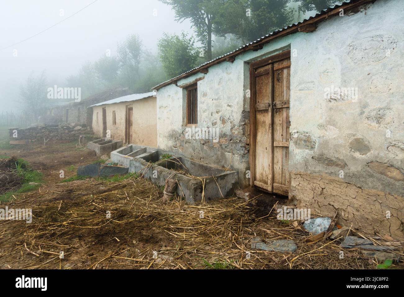 Domestic cattle house and feed troughs for cattle in rural India of the himalayan region. Uttarakhand India. Stock Photo