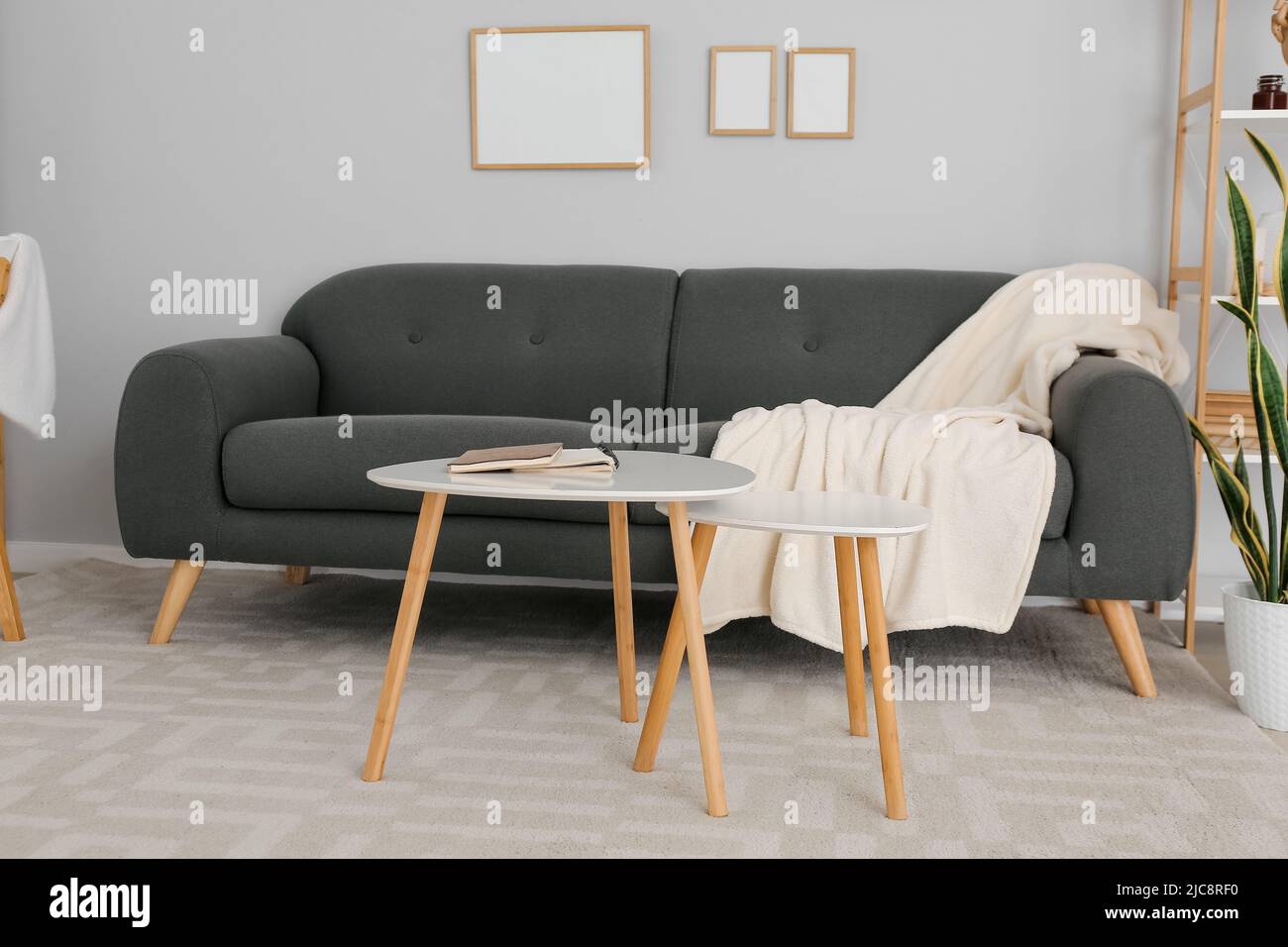 Interior of modern room with grey sofa and tables Stock Photo - Alamy