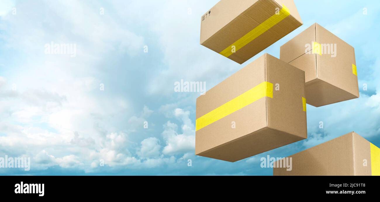 Brown delivery boxes flying on blue sky with clouds background Stock Photo