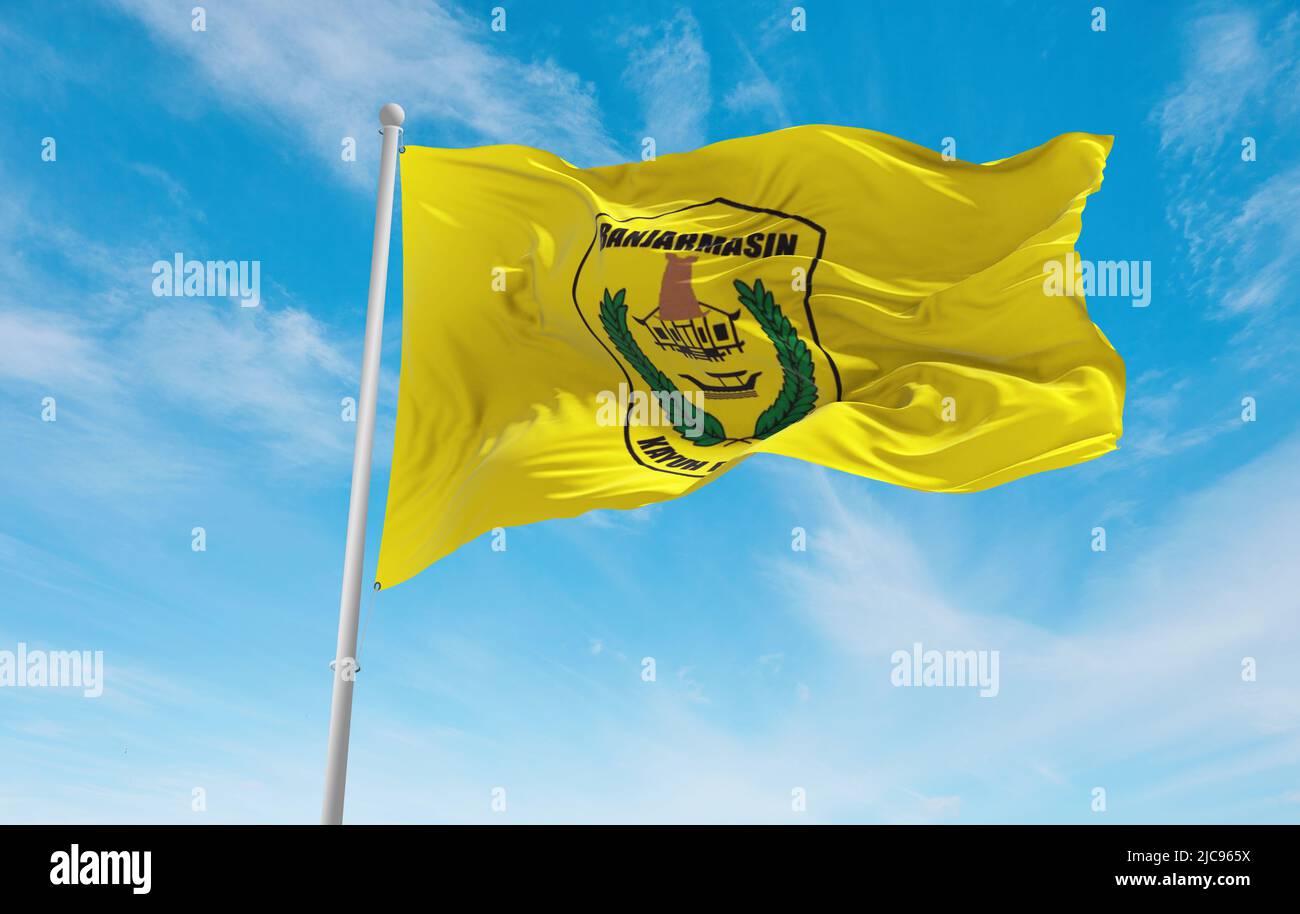official flag of Banjarmasin City Indonesia at cloudy sky background on sunset, panoramic view. Indonesian travel and patriot concept. copy space for Stock Photo