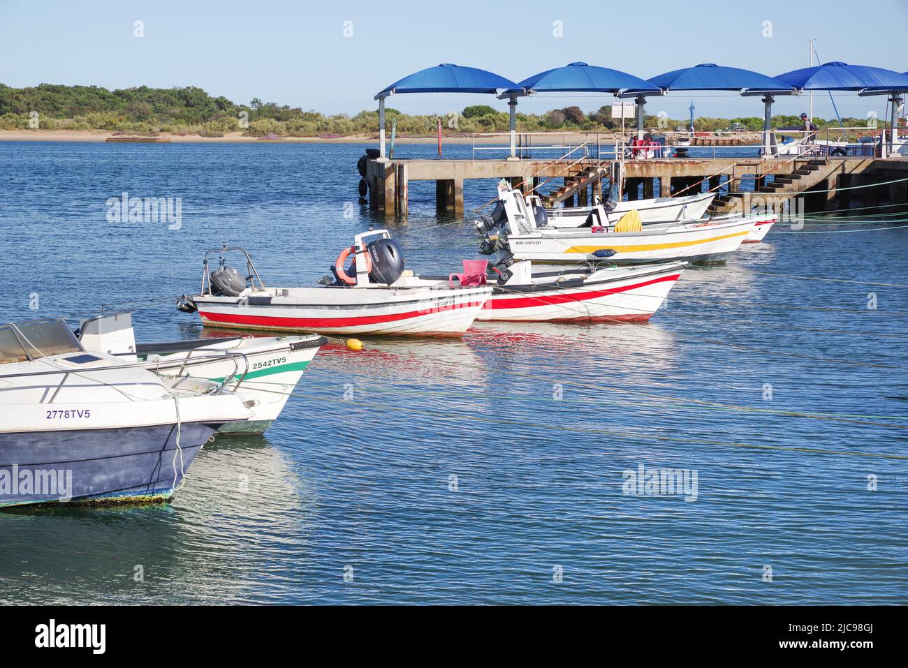 Colourful boats bobbing in the sea at Cais das Quatro Águas outside Tavira (Algarve, Portugal) Stock Photo