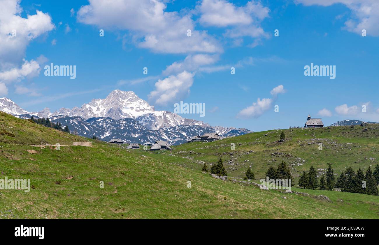 A picture of the landscape of Velika Planina, or Big Pasture Plateau, and its herder huts, with the Chapel of Mary of the Snows on the right and the K Stock Photo