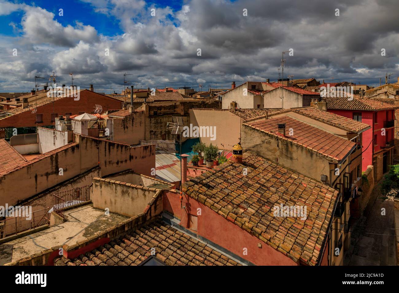 Aerial view of terracotta tiles of the roofs of medieval stone houses in Olite, Spain famous for a magnificent Royal Palace castle Stock Photo