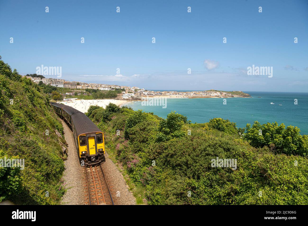 St Ives, UK. 11th June, 2022., train leaving st.ives ,cornwall on the local branch line A train runs on the picturesque St Ives Bay Railway Line passing through Lelant Beach in the background, en route to St Ives Credit: kathleen white/Alamy Live News Stock Photo
