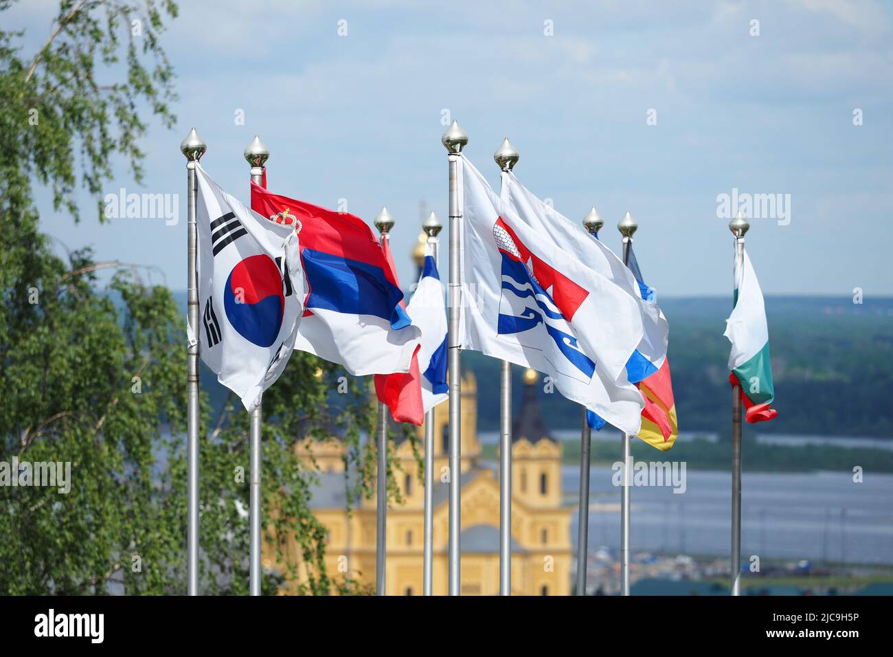 Various street flags of different countries develop on the flagpole.National symbols. Stock Photo