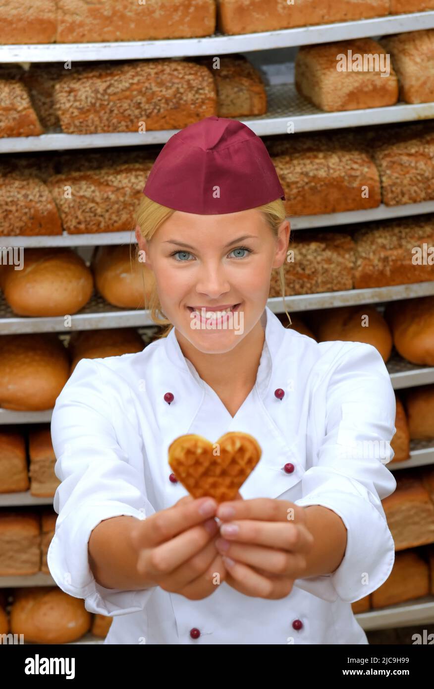 A young baker girl takes up her work in a bakery. She is seen in the