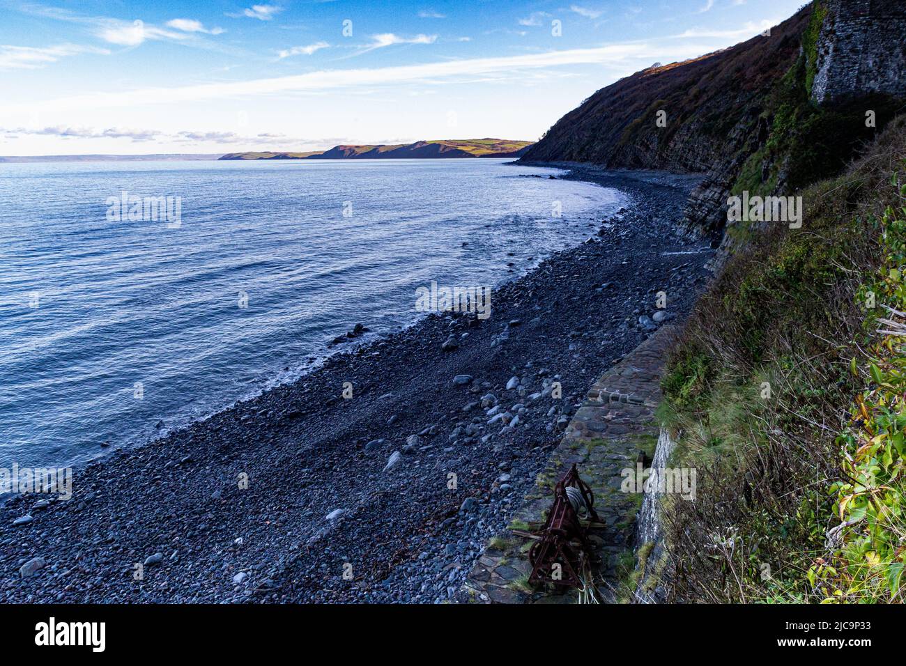 Colourful Winter View Looking Along Bucks Mills Beach at High Tide With Bright Coloured Wet Pebbles, Winding Gear and North Devon Coast,  Bucks Mills Stock Photo