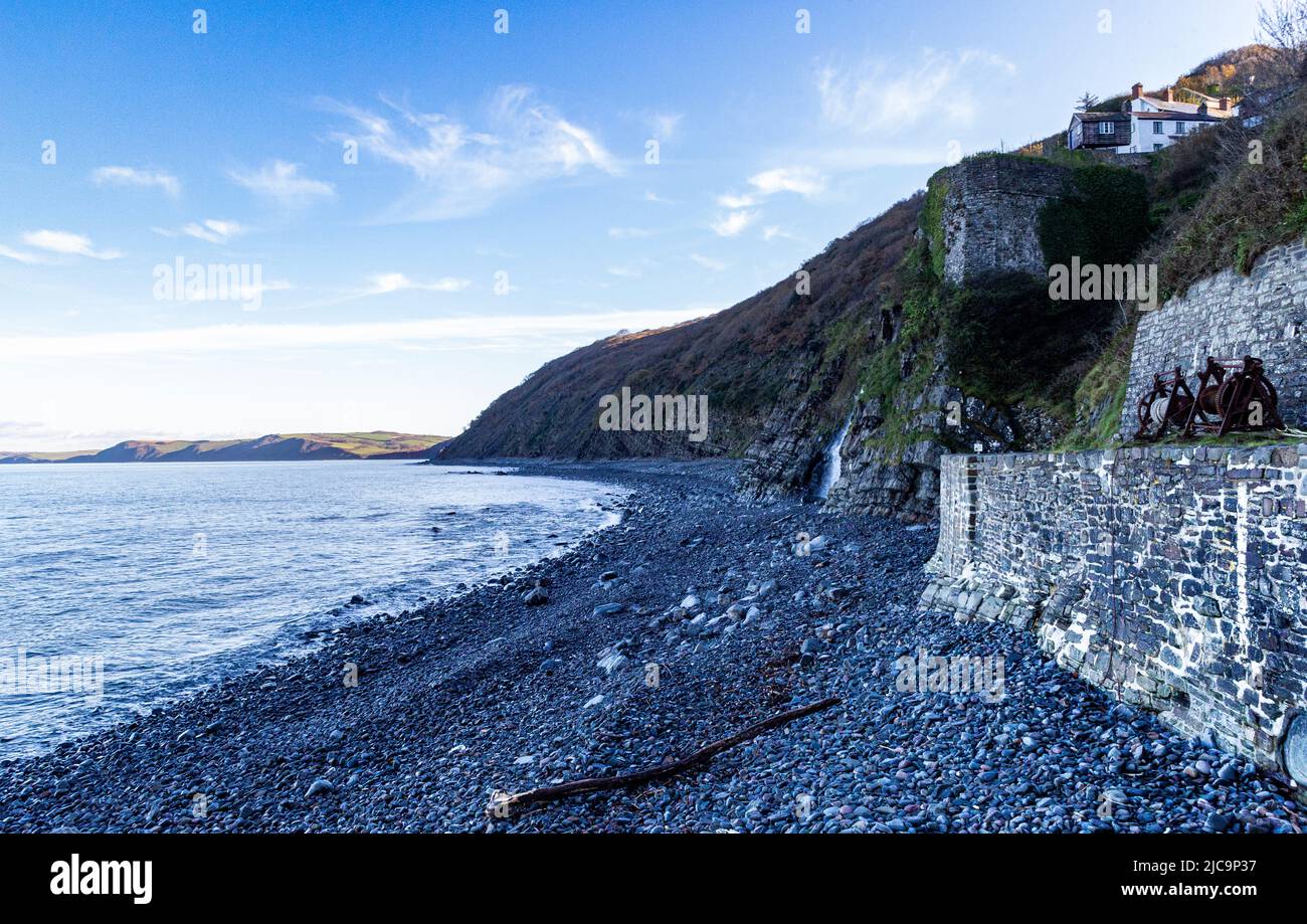 Colourful Winter View Along Bucks Mills Beach at High Tide With Bright Coloured Wet Pebbles, Winding Gear, Protective Wall and North Devon Coast Stock Photo