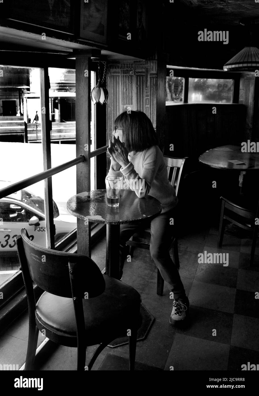 A woman enjoys a pint of beer  at Vesuvio Cafe, a landmark bar in San Francisco, California, frequented by members of the 1950s Beat Generation. Stock Photo