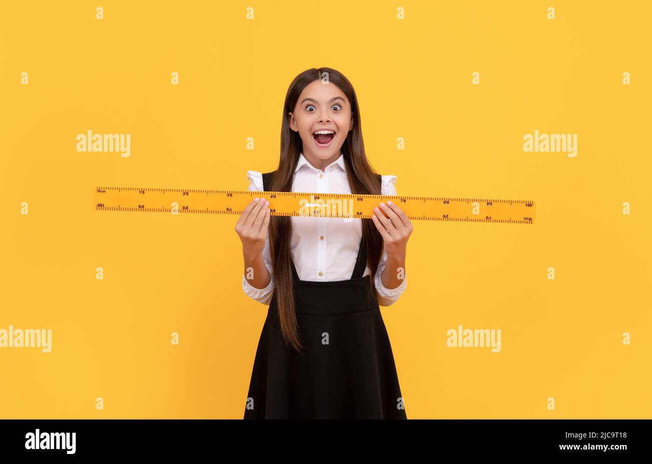 amazed teen girl in school uniform hold mathematics ruler for measuring ...