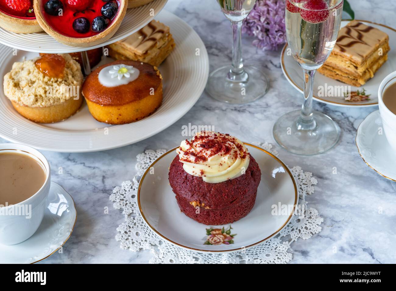 Selection of gourmet cakes with coffee and sparkling wine on a table Stock Photo