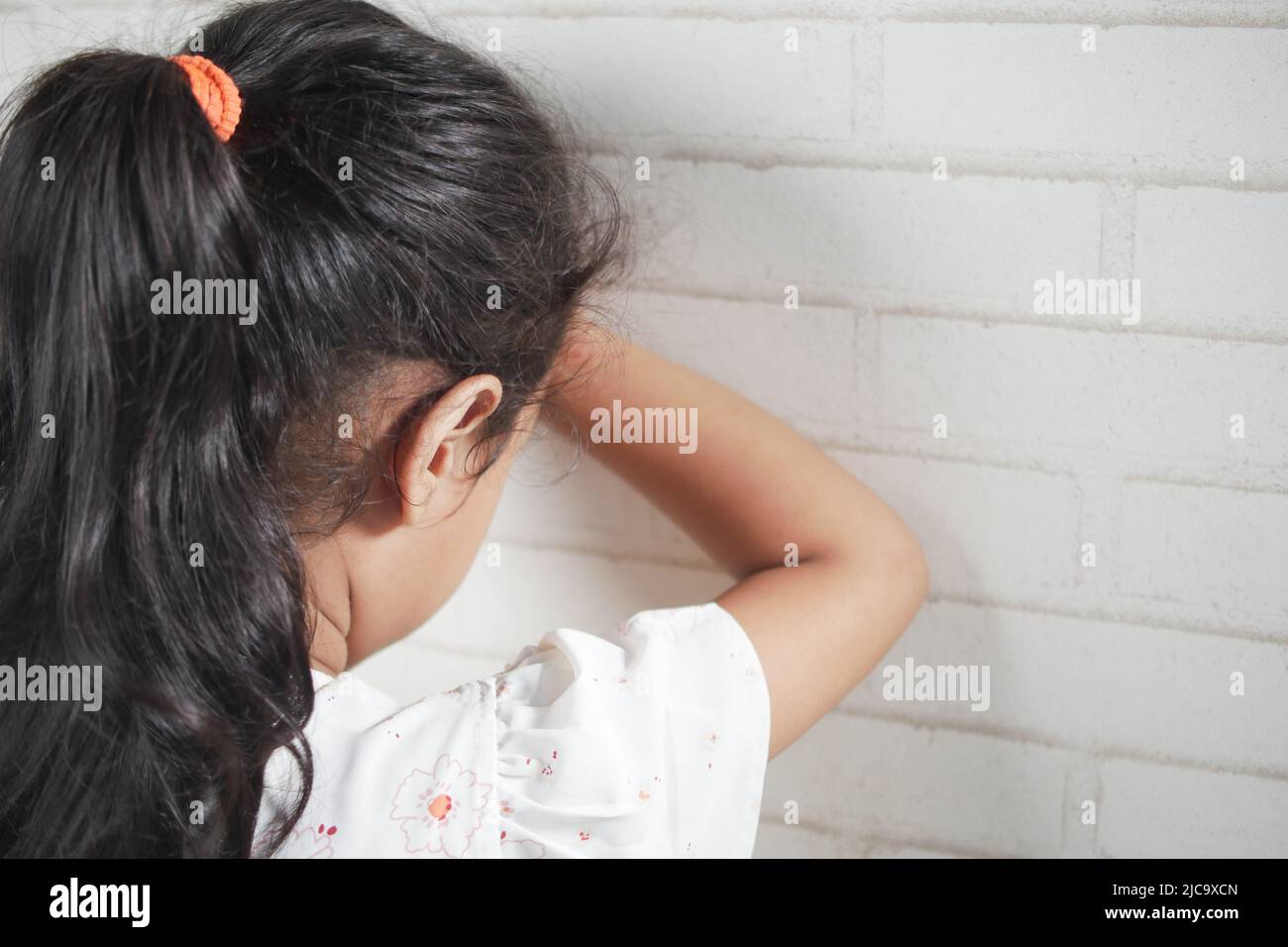 sad child child hiding her face  Stock Photo