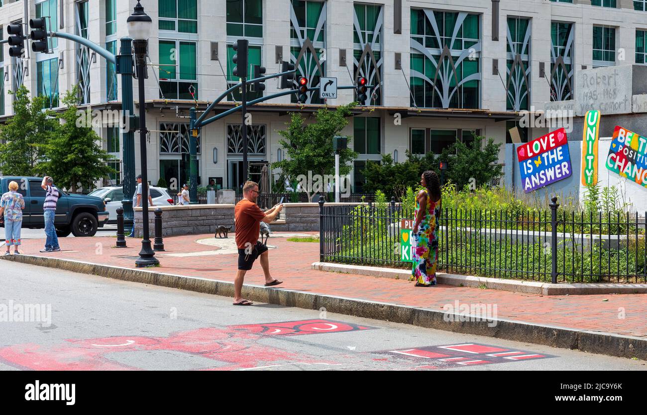 ASHEVILLE, NC, USA-5 JUNE 2022: Man taking photo of woman  in Pack Square Park in downtown. Stock Photo