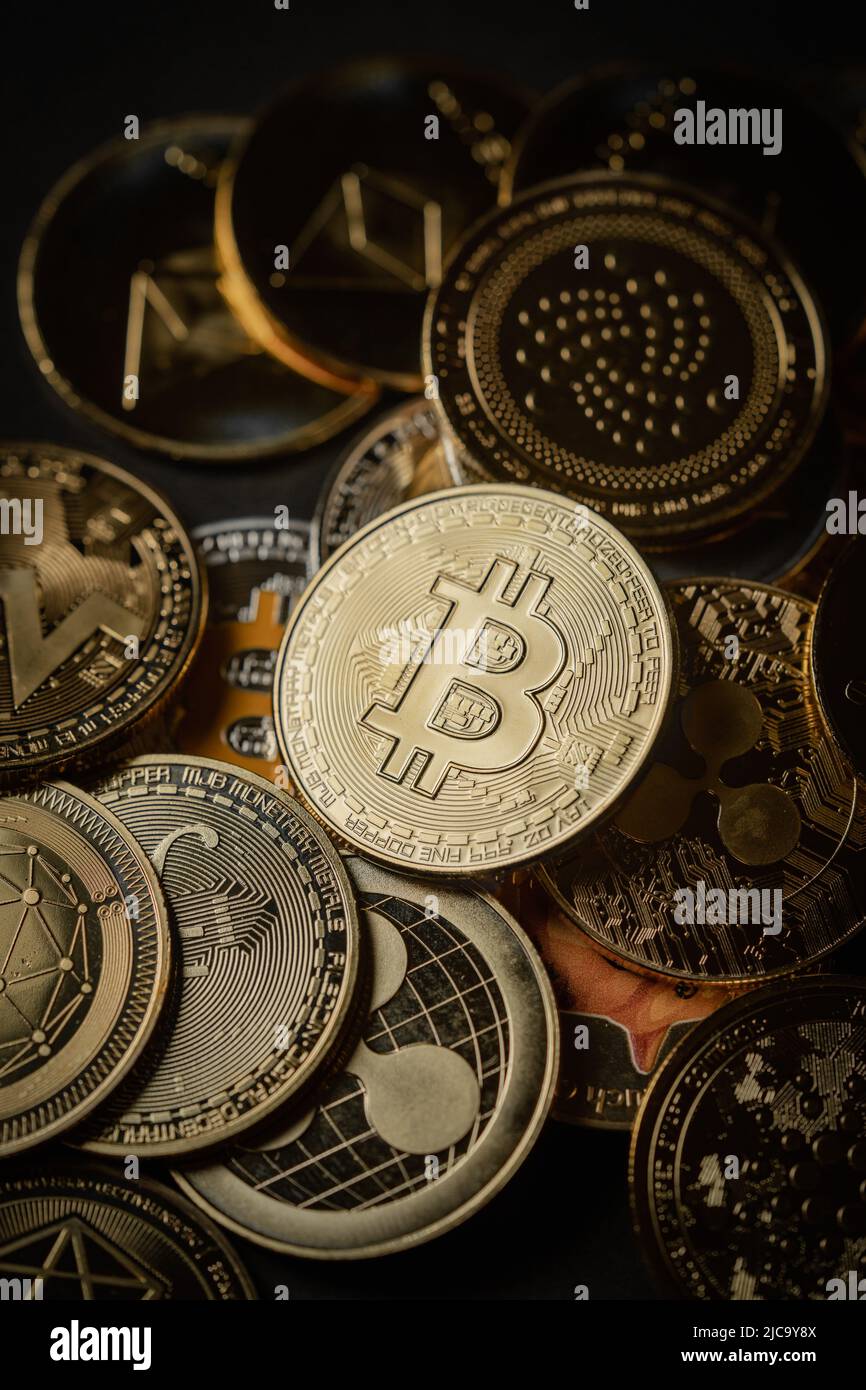 Close up shot of a golden Bitcoin in a stack, among other various digital cryptocurrencies. Stock Photo