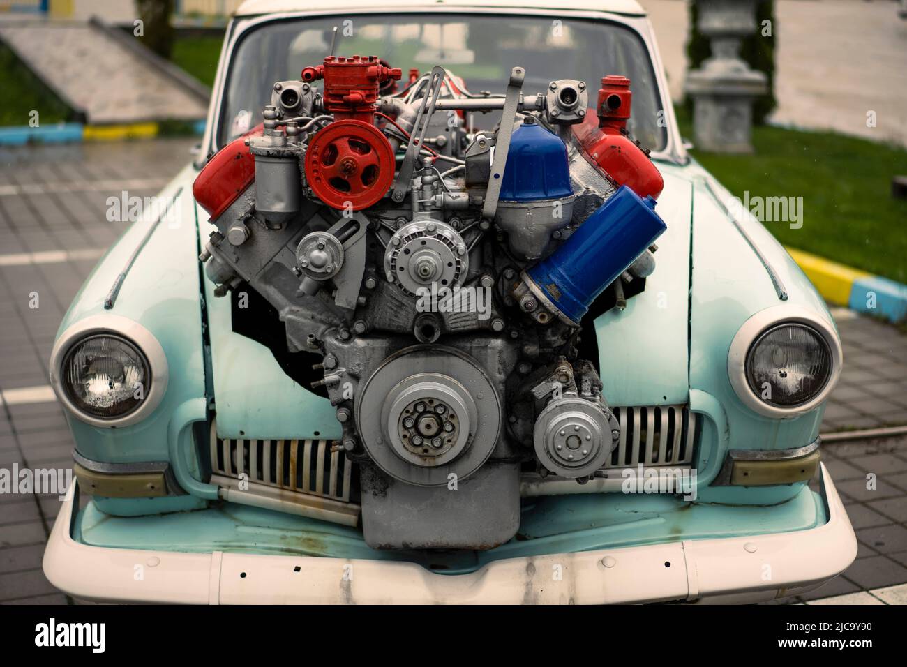 Image of a vintage tuned car, with a large engine sticking out of its