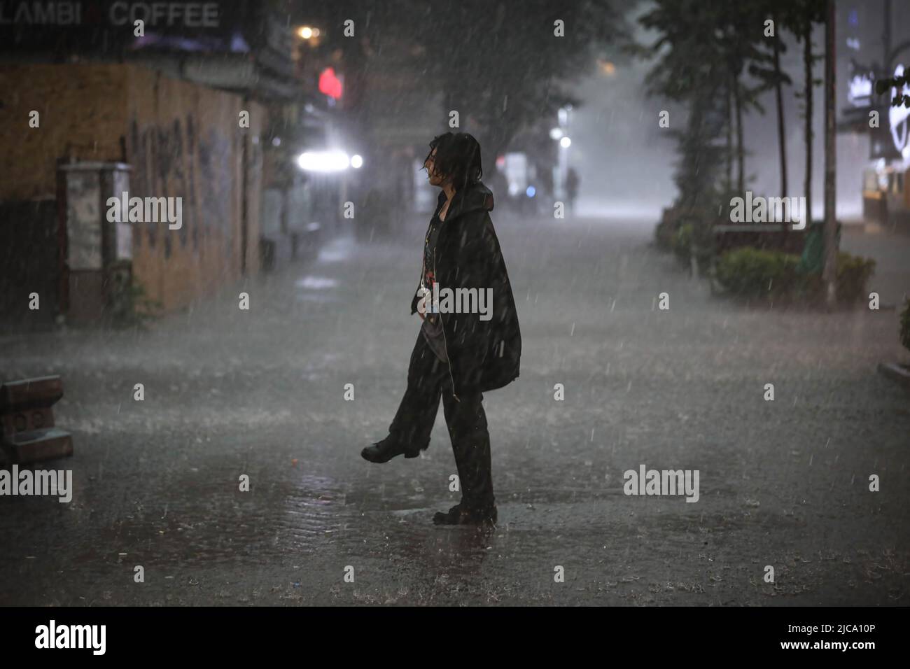 Turkey Rain A woman stands in the middle of the road during a rainfall. Heavy rains ...