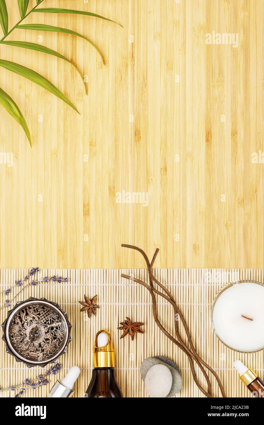Self care, spa, relax composition with natural oils, candles and aroma sticks on a wooden background with palm leaf and copy space. Depression treatme Stock Photo
