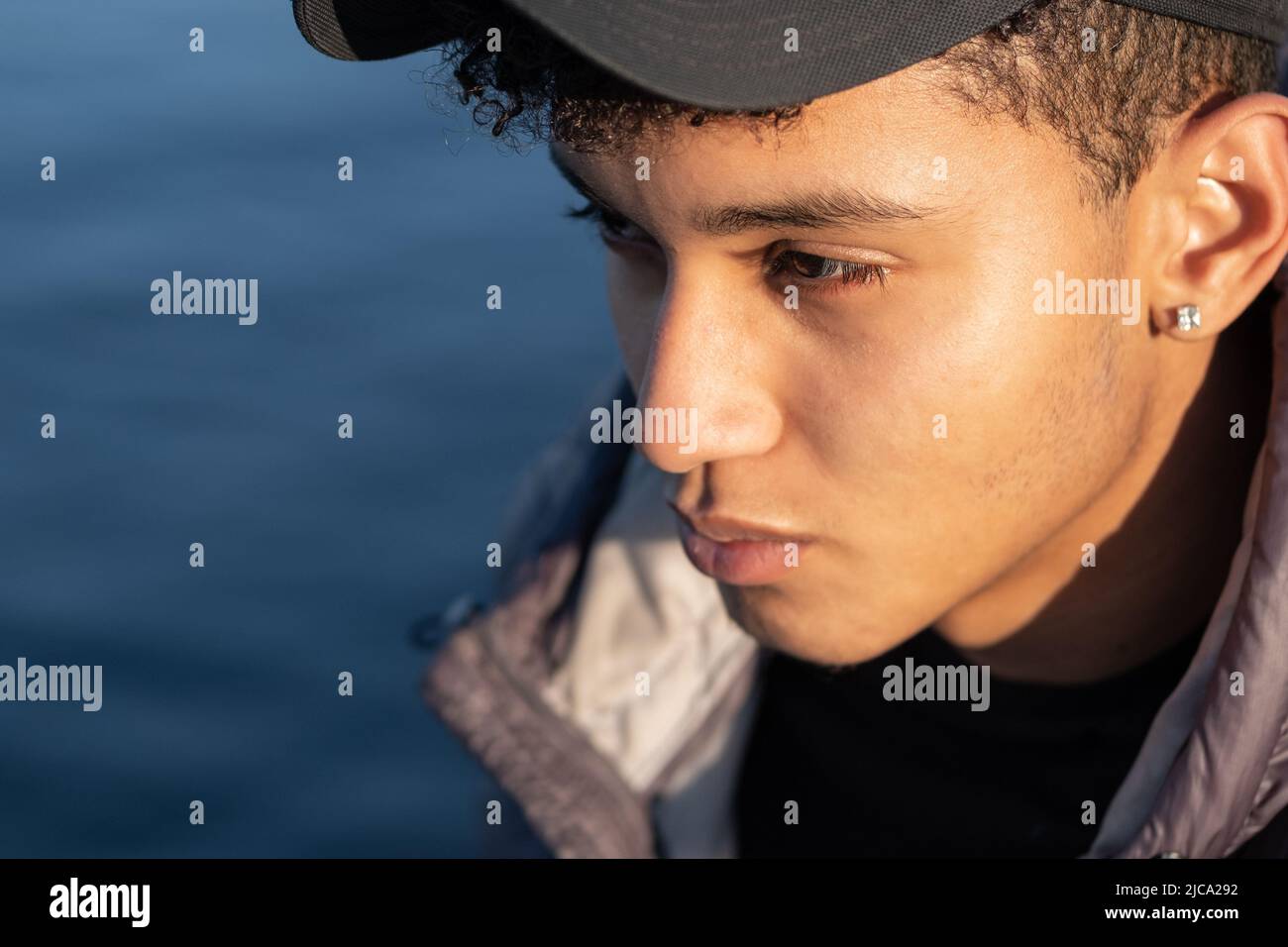 Close-up of the face of a handsome young man of Latin American descent. Unusual angle, copy space. Stock Photo