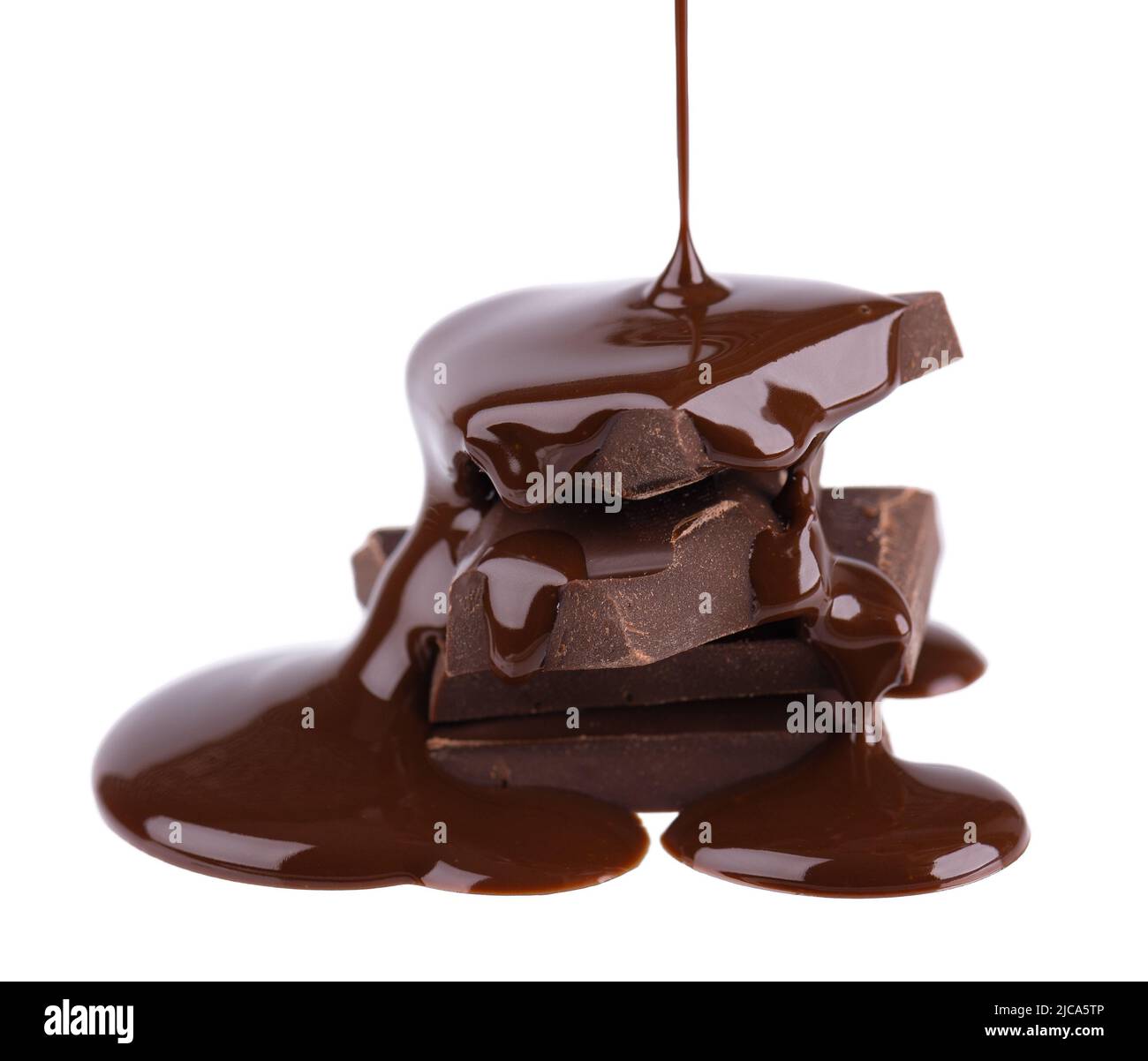 Chocolate pieces stack and chocolate syrup isolated on white background. Close up Stock Photo
