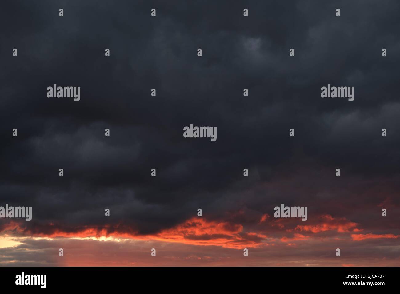 Thunderclouds with breaking rays sun at sunset Stock Photo