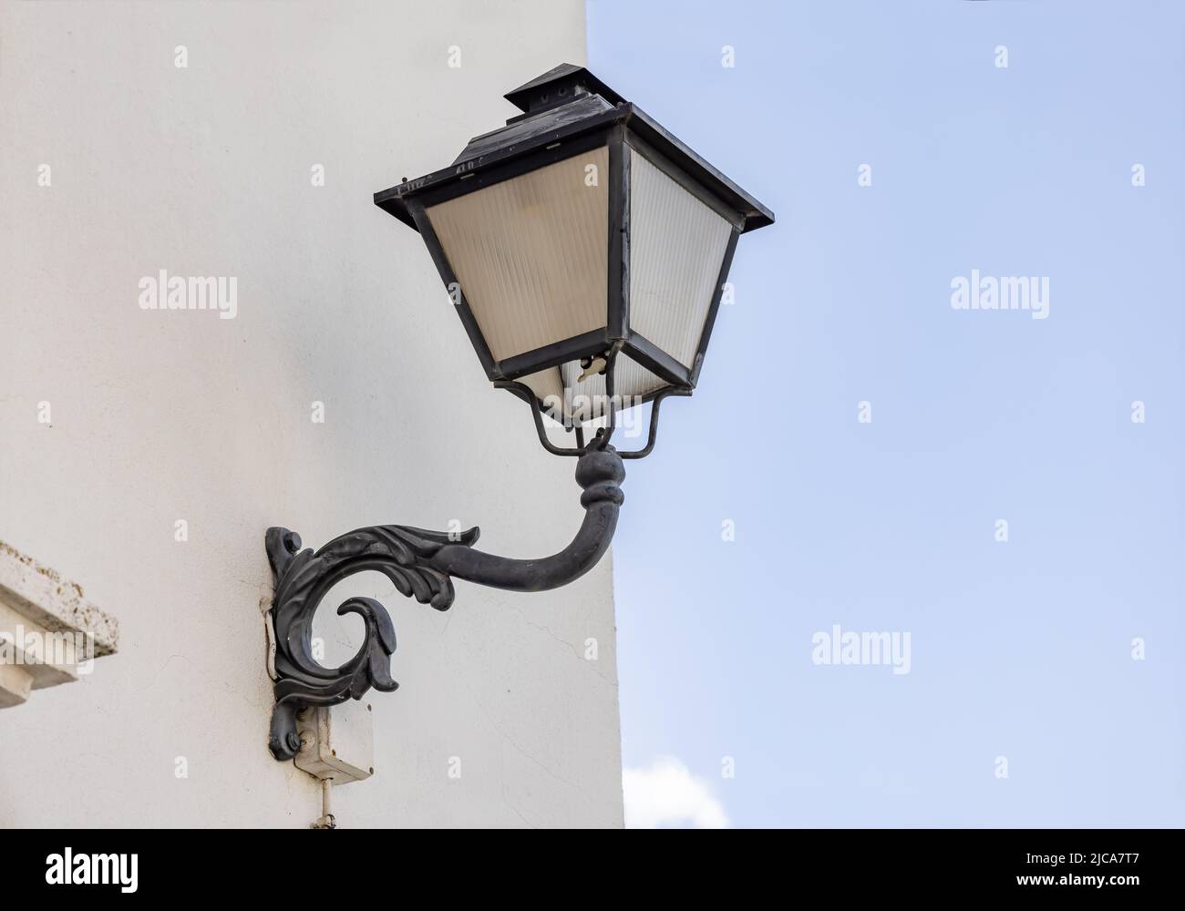 Iron wall lamp in a whitewashed wall Stock Photo