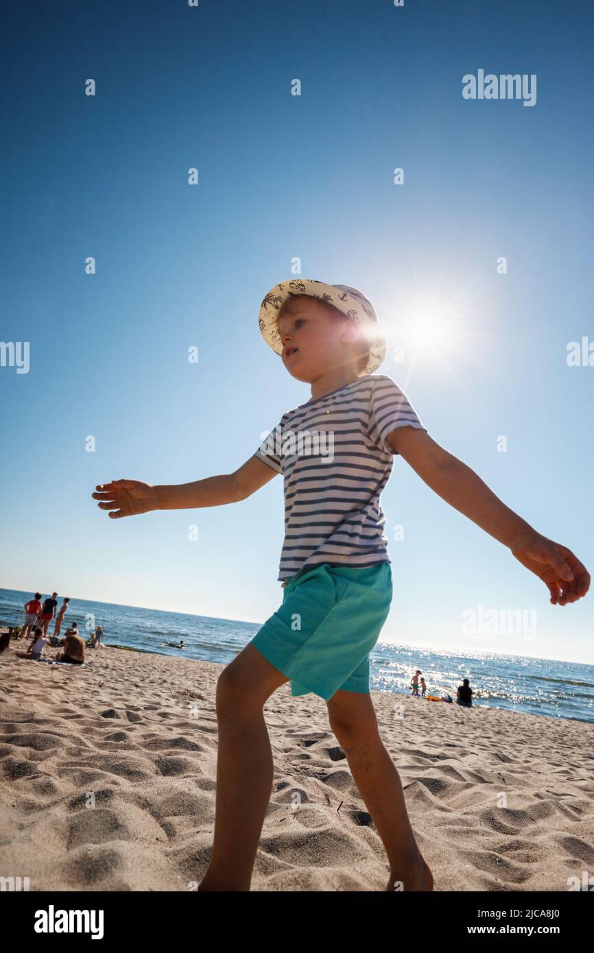 Adorable little boy on the sand beach at Baltic sea Lithuania. Small child enjoying vacation by the sea. Travelling with kids Stock Photo