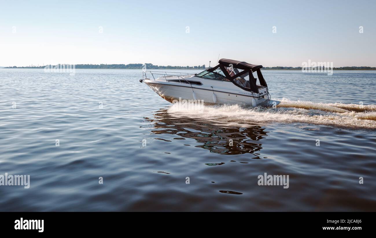 On a summer day, a small boat flies at high speed in the lagoon towards the Vente cape Stock Photo