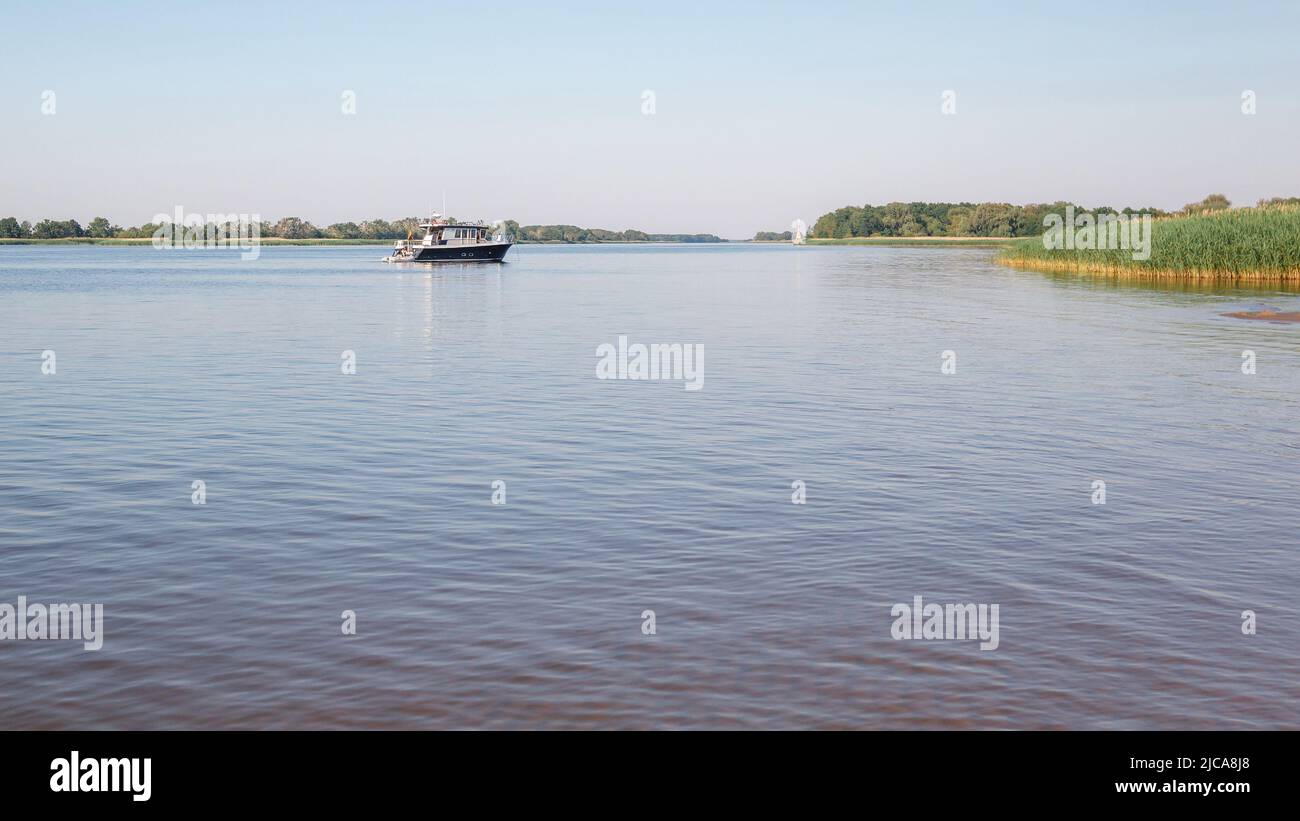 On a clear summer day, a small fishing boat returns home Stock Photo
