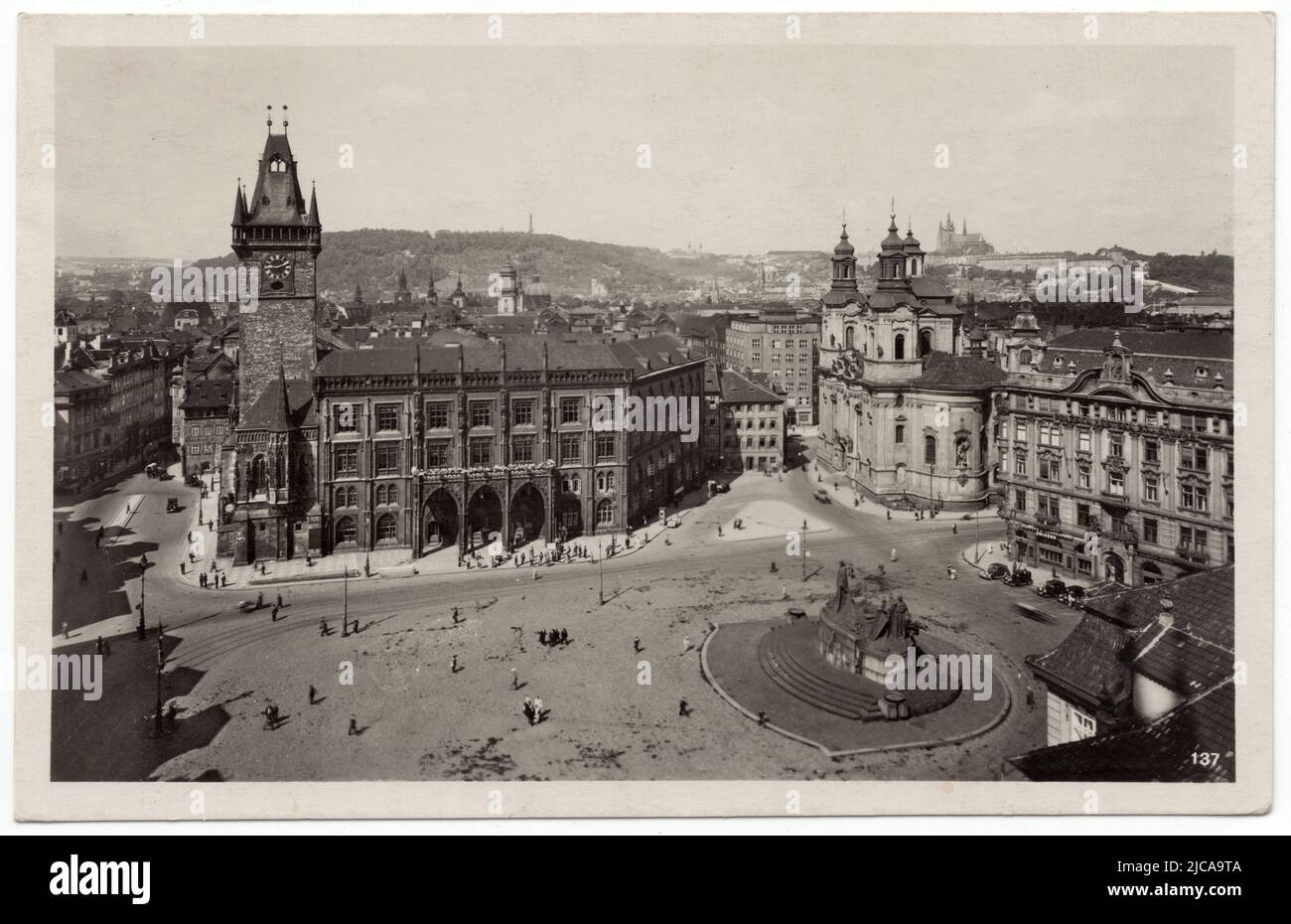 Old Town Hall (Staroměstská radnice) and Saint Nicholas' Church (Kostel svatého Mikuláše) in Old Town Square (Staroměstské náměstí) in Prague, Czechoslovakia, pictured from above, depicted in the Czechoslovak vintage postcard issued around 1940. The neo-Gothic wing of the Old Town Hall which was destroyed in the last days of the World War II is seen in the centre. The monument to Jan Hus designed by Czech sculptor Ladislav Šaloun (1915) is seen in the foreground at the right. Courtesy of the Azoor Postcard Collection. Stock Photo