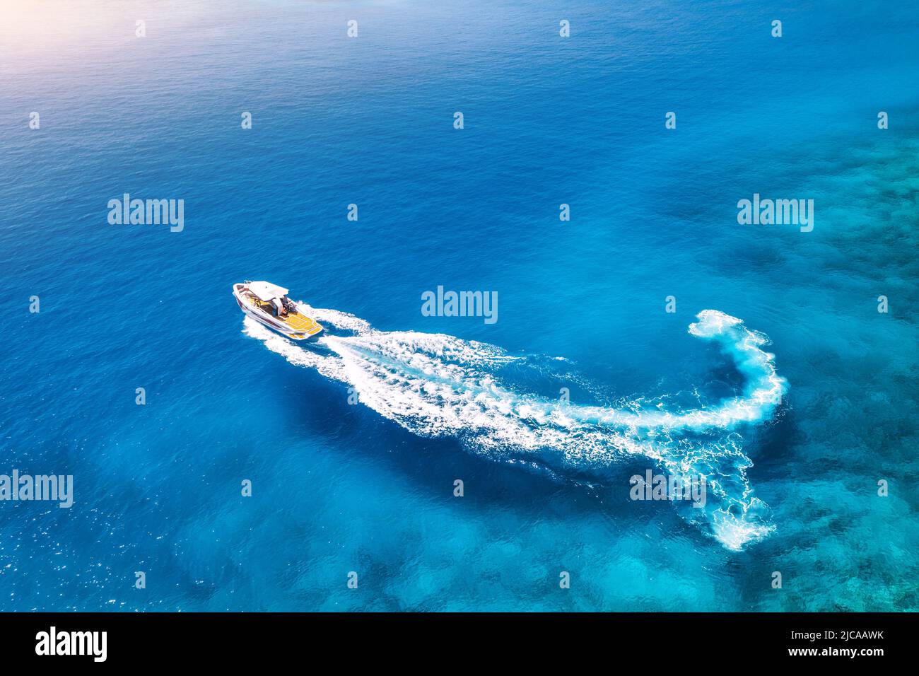 Aerial view of the speed boat in clear blue water at sunset Stock Photo ...