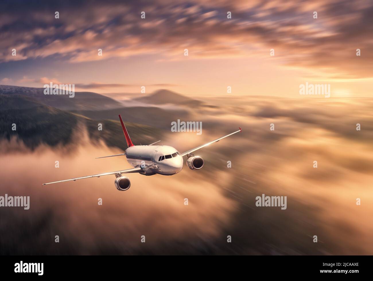 Airplane is flying above the clouds at sunset in summer Stock Photo - Alamy