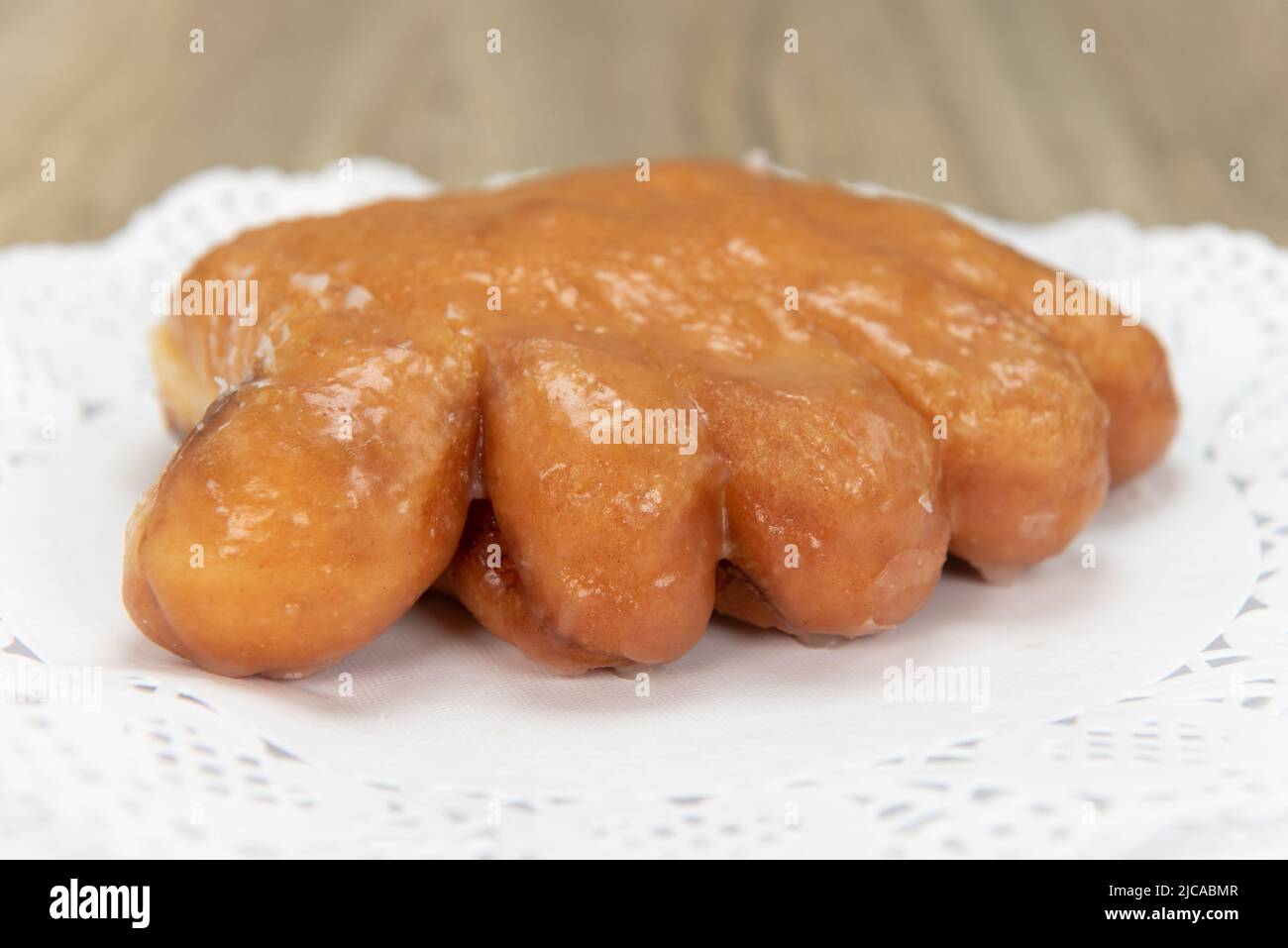 Tempting fresh from the oven bear claw donut from the bakery served on a plate. Stock Photo