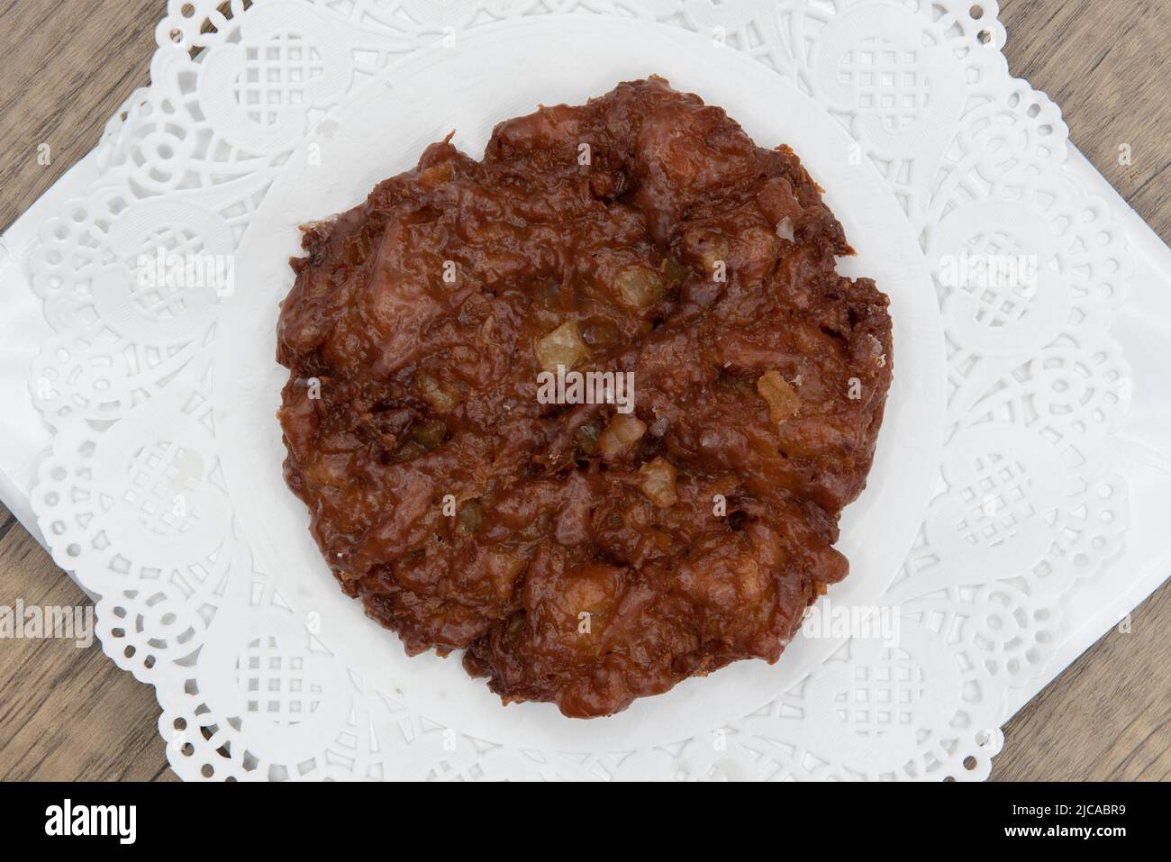 Overhead view of tempting fresh from the oven apple fritter donut from the bakery served on a plate. Stock Photo