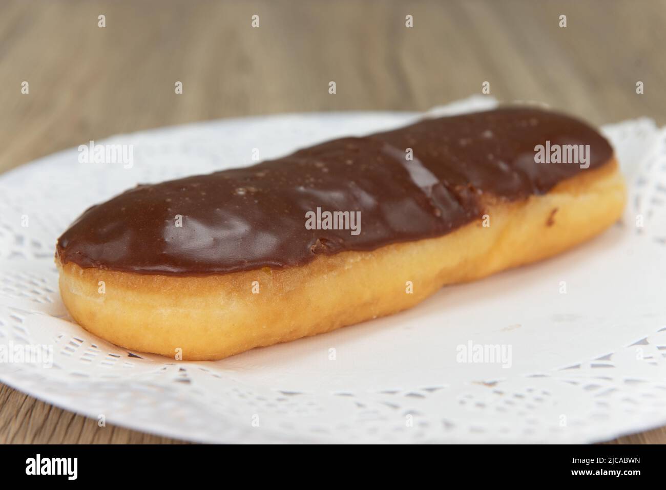 Tempting fresh from the oven chocolate bar donut from the bakery served on a plate. Stock Photo