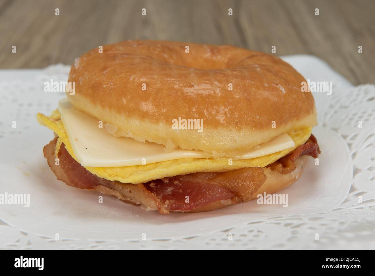 Tempting fresh from the oven glazed donut sanwich with eggs, bacon, and