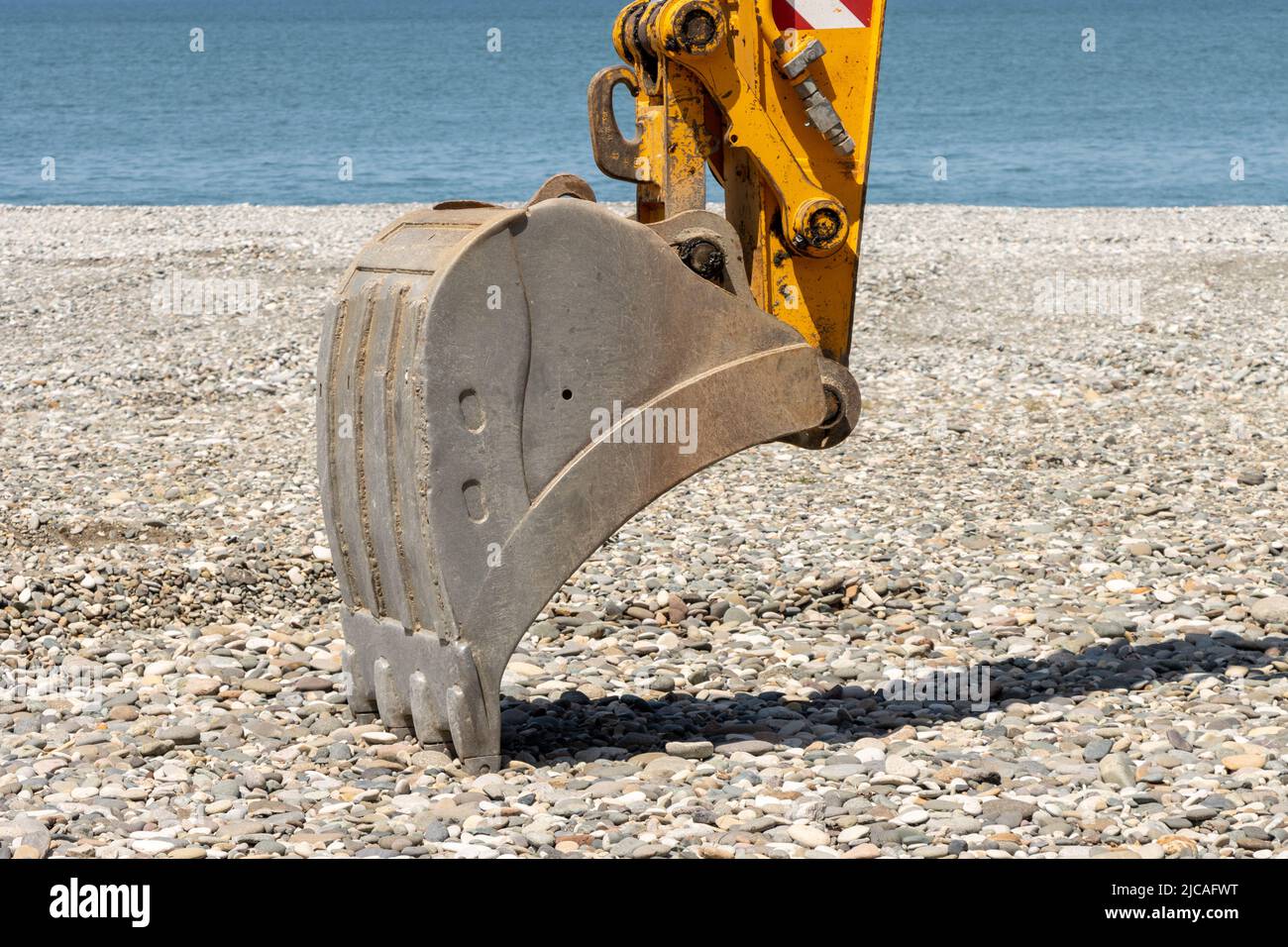 Construction equipment, excavator dozer bucket on the beach by the sea Stock Photo